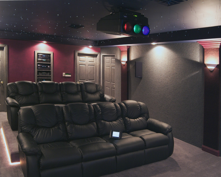 Photo of a mid-sized traditional enclosed home theatre in Other with grey walls, carpet and a projector screen.