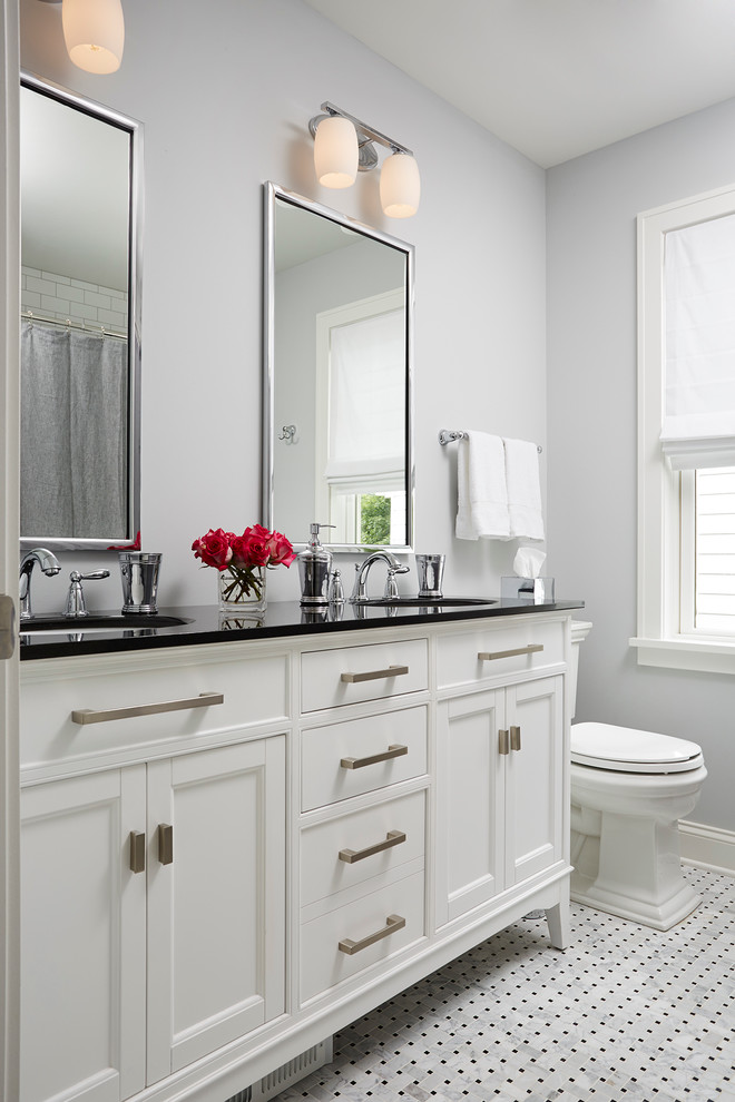 Inspiration for a mid-sized transitional master black and white tile and porcelain tile mosaic tile floor tub/shower combo remodel in Minneapolis with an undermount sink, white cabinets, gray walls, recessed-panel cabinets, a two-piece toilet and solid surface countertops