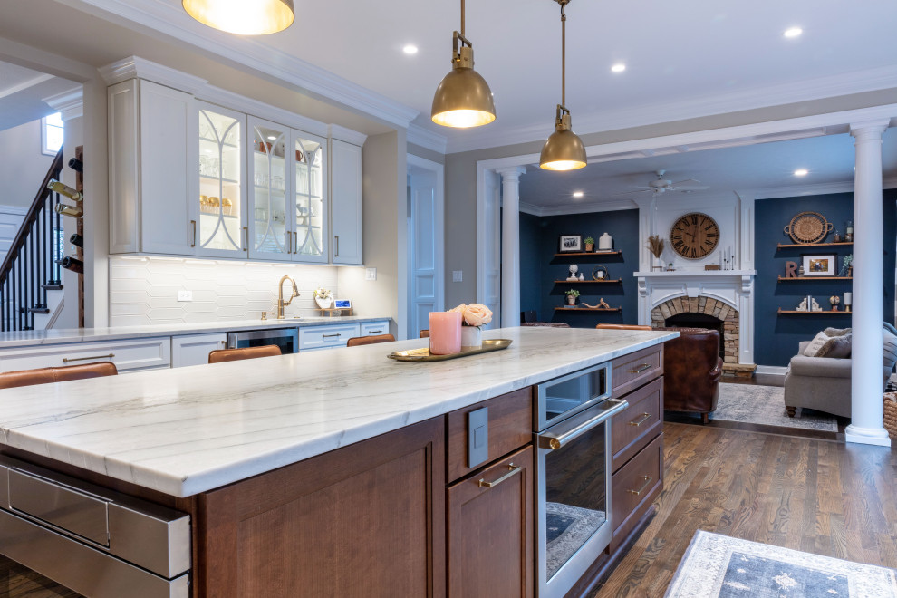 Inspiration for a transitional medium tone wood floor kitchen remodel with shaker cabinets, quartzite countertops, stainless steel appliances and an island