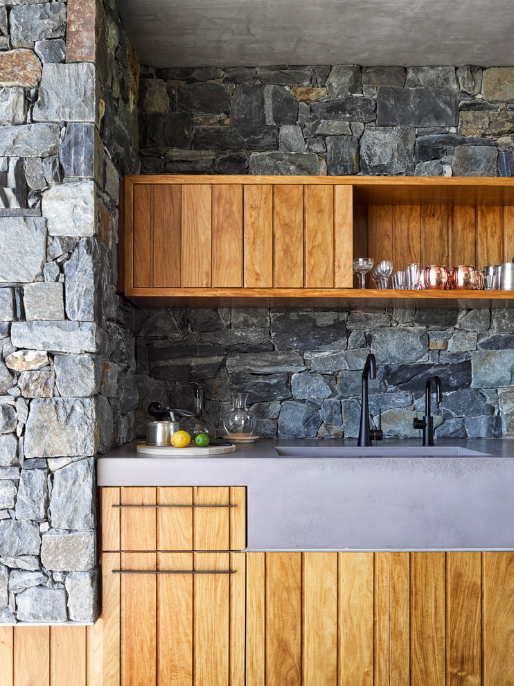 Inspiration for a small country single-wall home bar in Brisbane with an integrated sink, medium wood cabinets, concrete benchtops, grey splashback, stone tile splashback and flat-panel cabinets.