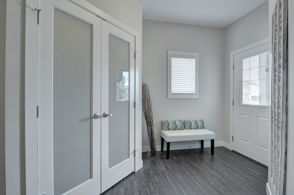 Foyer - mid-sized transitional vinyl floor and black floor foyer idea in Edmonton with beige walls and a white front door