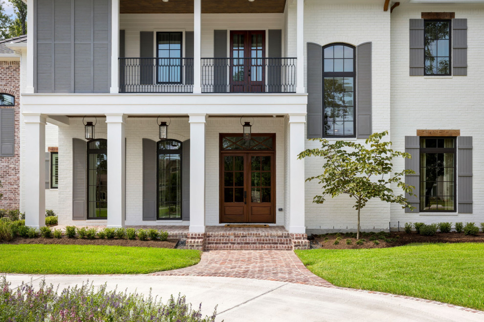 Großes, Zweistöckiges Einfamilienhaus mit Backsteinfassade, weißer Fassadenfarbe, Walmdach, Misch-Dachdeckung und grauem Dach in Houston