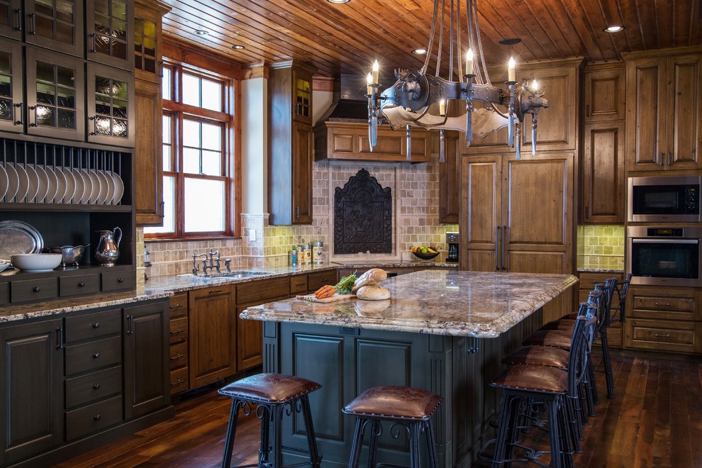 This is an example of a large country l-shaped eat-in kitchen in Minneapolis with raised-panel cabinets, distressed cabinets, granite benchtops and with island.