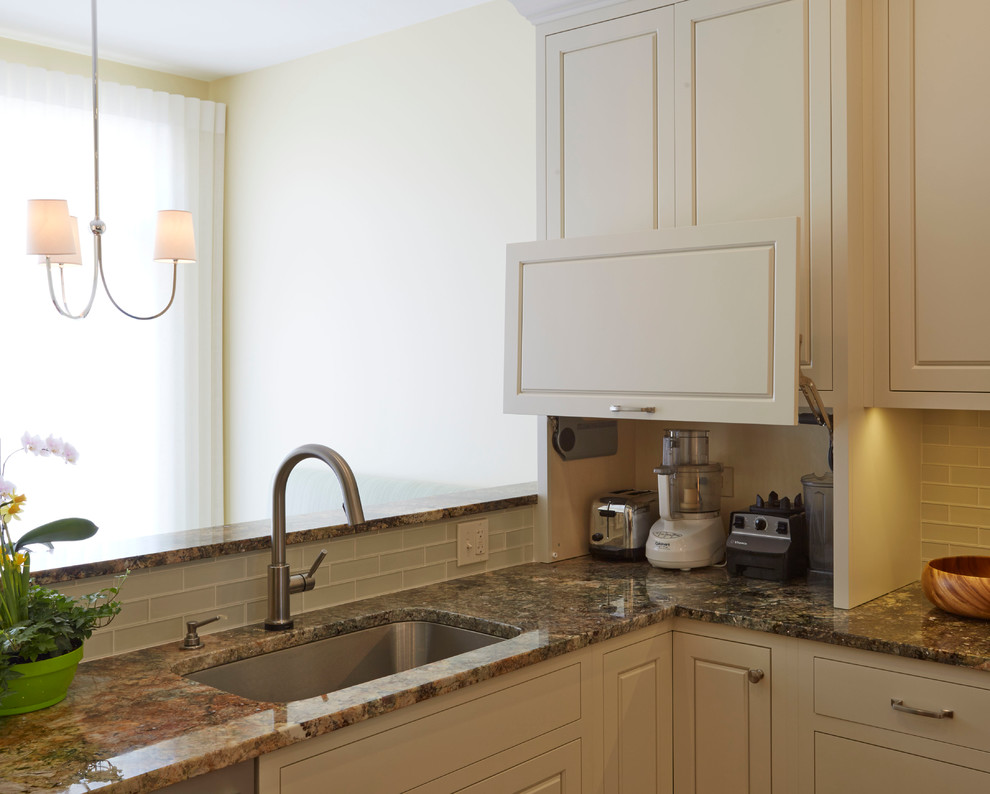 Mid-sized transitional u-shaped medium tone wood floor enclosed kitchen photo in Chicago with a single-bowl sink, raised-panel cabinets, white cabinets, granite countertops, white backsplash, glass tile backsplash, stainless steel appliances and an island