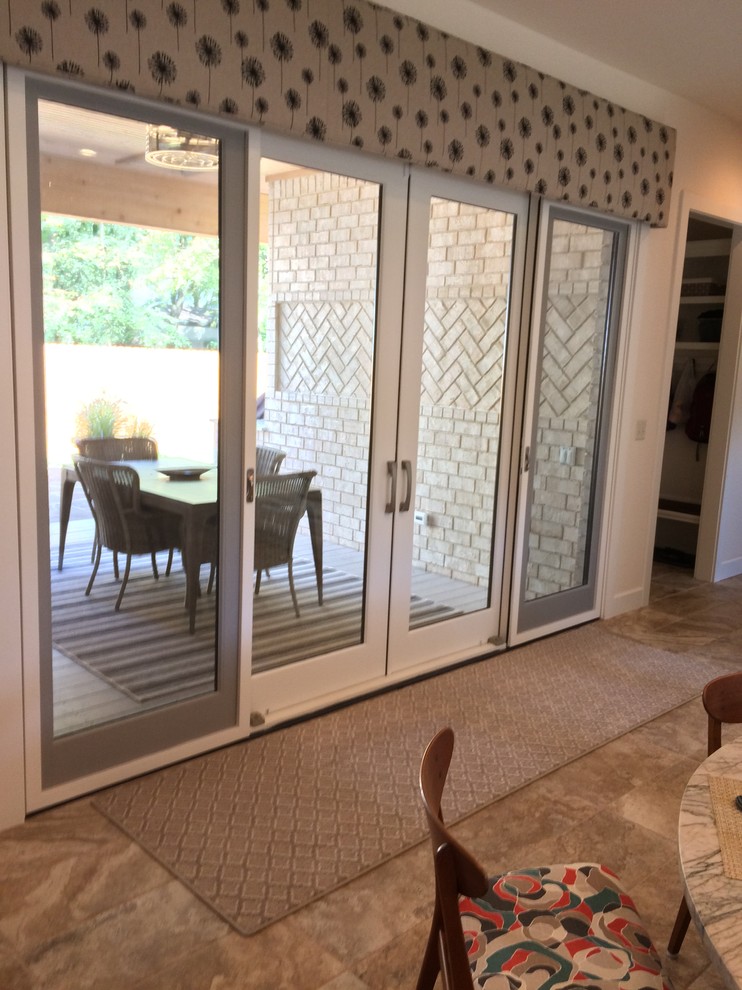 Example of a mid-sized transitional u-shaped porcelain tile kitchen design with white cabinets, marble countertops, stainless steel appliances and an island