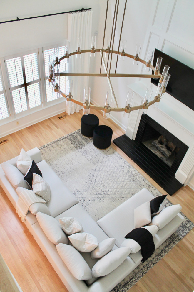 Mittelgroßes, Abgetrenntes Modernes Wohnzimmer mit weißer Wandfarbe, hellem Holzboden, Kamin, Kaminumrandung aus Backstein, gewölbter Decke und vertäfelten Wänden in Raleigh