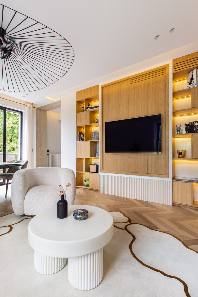 Foto de salón abierto actual con paredes blancas, suelo de madera en tonos medios y televisor colgado en la pared
