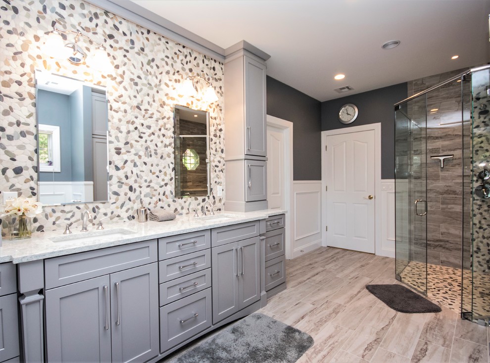 Design ideas for a large transitional master bathroom in Providence with recessed-panel cabinets, grey cabinets, a curbless shower, a two-piece toilet, beige tile, pebble tile, grey walls, ceramic floors, an undermount sink, beige floor and a hinged shower door.