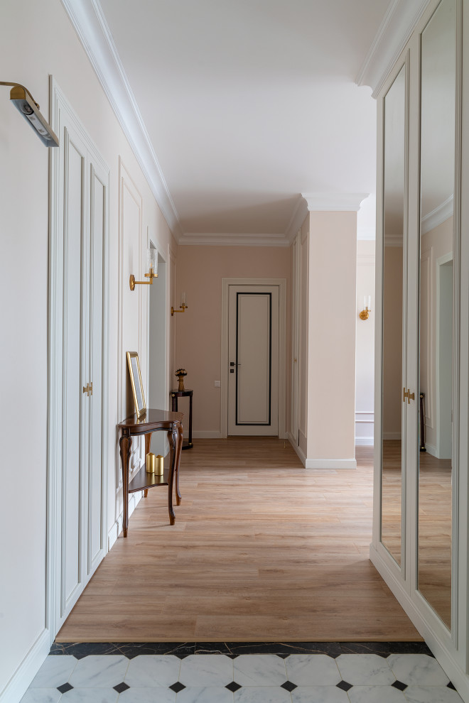 Пример оригинального дизайна: узкая прихожая среднего размера в стиле неоклассика (современная классика) с бежевыми стенами, полом из керамогранита, одностворчатой входной дверью, коричневой входной дверью и бежевым полом