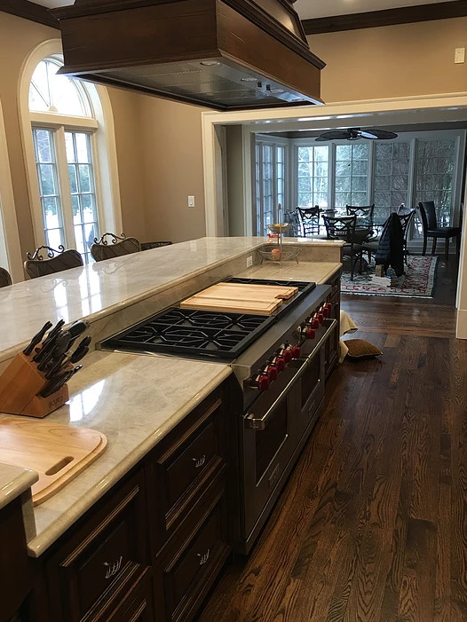 Large transitional galley dark wood floor and brown floor eat-in kitchen photo in Chicago with recessed-panel cabinets, dark wood cabinets, stainless steel appliances, an island and white backsplash