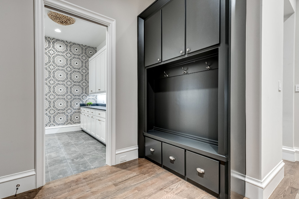 Photo of a contemporary galley dedicated laundry room in Dallas with an undermount sink, shaker cabinets, white cabinets, quartz benchtops, multi-coloured walls, ceramic floors, a side-by-side washer and dryer, grey floor and blue benchtop.
