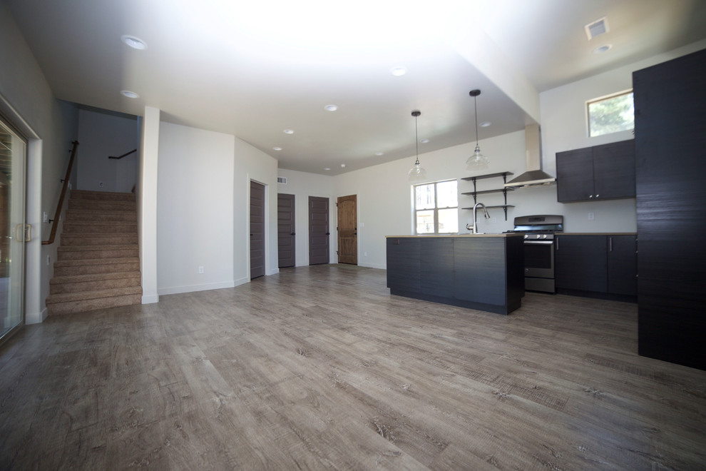 Open concept kitchen - small rustic medium tone wood floor open concept kitchen idea in Phoenix with flat-panel cabinets, black cabinets, wood countertops and an island