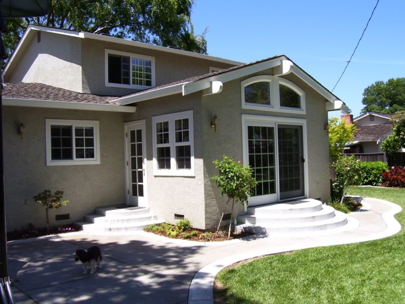 Photo of a large traditional two-storey stucco beige house exterior in San Francisco with a gable roof and a shingle roof.