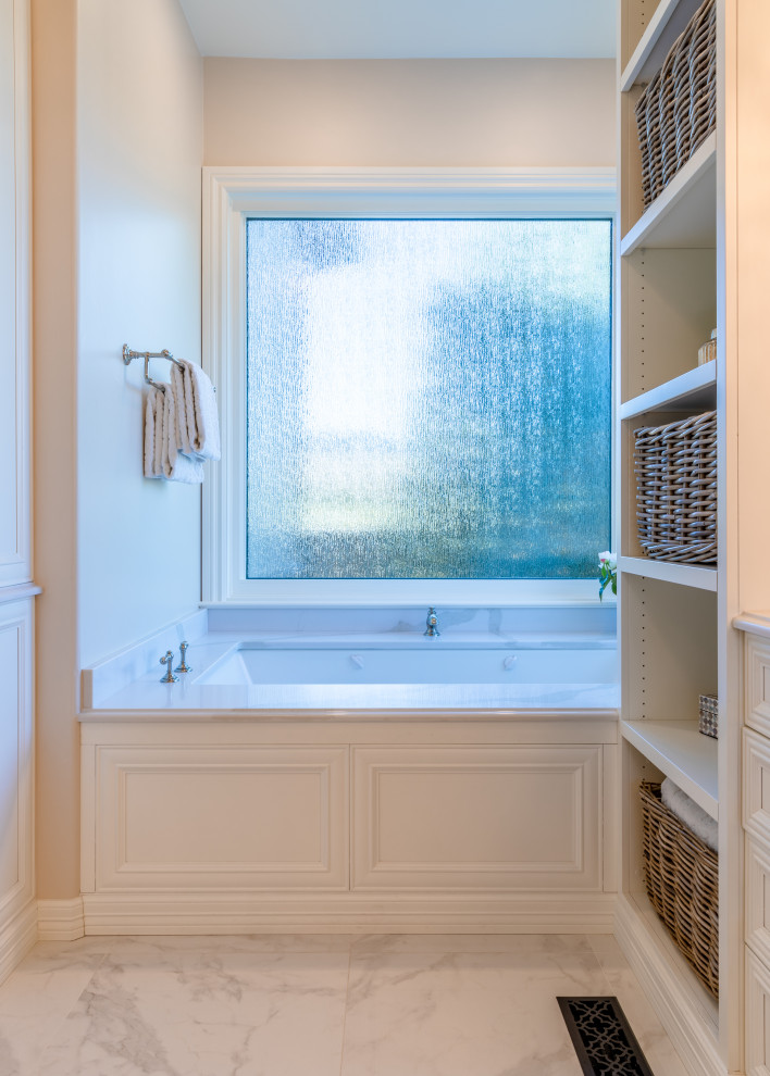 Idéer för stora vintage vitt en-suite badrum, med släta luckor, vita skåp, ett platsbyggt badkar, beige kakel, marmorkakel, klinkergolv i keramik, bänkskiva i kvarts och vitt golv