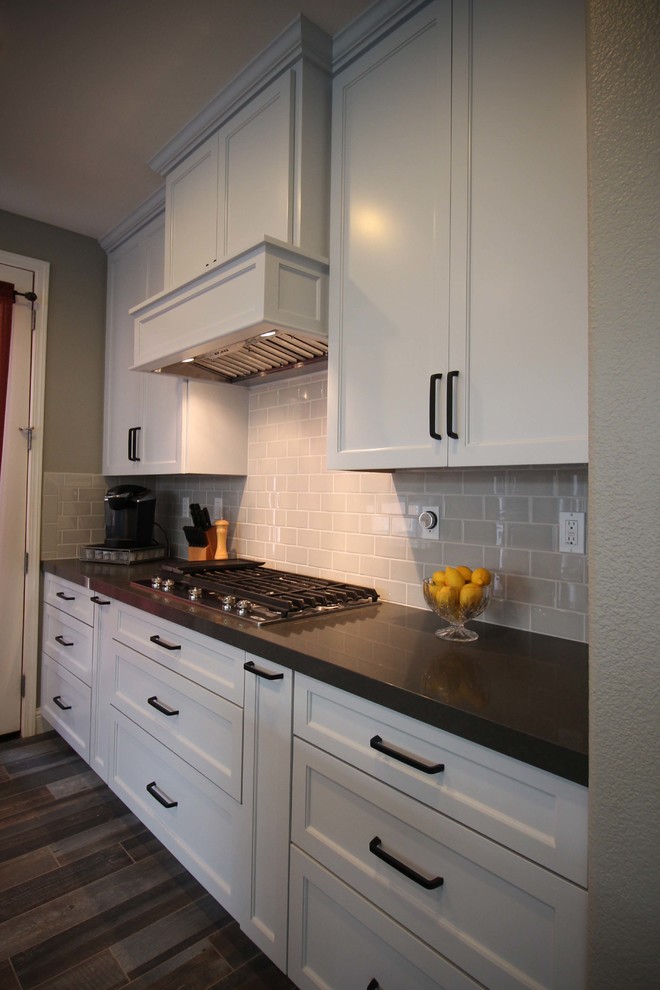Example of a mid-sized transitional l-shaped porcelain tile open concept kitchen design in Sacramento with an undermount sink, shaker cabinets, gray cabinets, quartz countertops, gray backsplash, ceramic backsplash, stainless steel appliances and an island