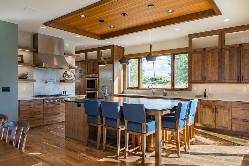 Design ideas for a mid-sized country eat-in kitchen in Denver with an undermount sink, medium wood cabinets, soapstone benchtops, white splashback, stainless steel appliances, medium hardwood floors, with island, shaker cabinets and subway tile splashback.