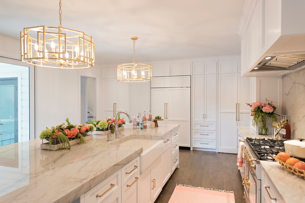 Open concept kitchen - large transitional l-shaped medium tone wood floor and brown floor open concept kitchen idea with a farmhouse sink, recessed-panel cabinets, white cabinets, quartzite countertops, white backsplash, stone slab backsplash, paneled appliances and an island