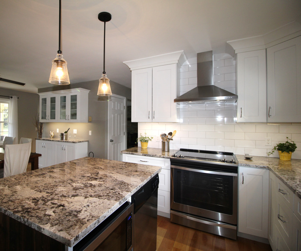 Eat-in kitchen - mid-sized transitional l-shaped light wood floor eat-in kitchen idea in Burlington with a single-bowl sink, shaker cabinets, white cabinets, granite countertops, white backsplash, ceramic backsplash, stainless steel appliances and an island