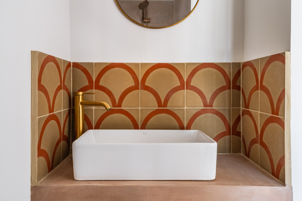 Immagine di una piccola stanza da bagno con doccia mediterranea con piastrelle multicolore, piastrelle in ceramica, pareti bianche, lavabo da incasso, top in cemento, top beige e un lavabo