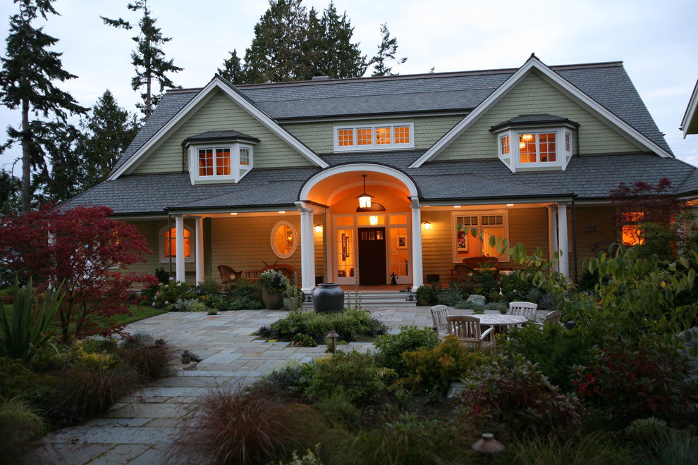 This is an example of a large traditional two-storey green exterior in Seattle with wood siding.