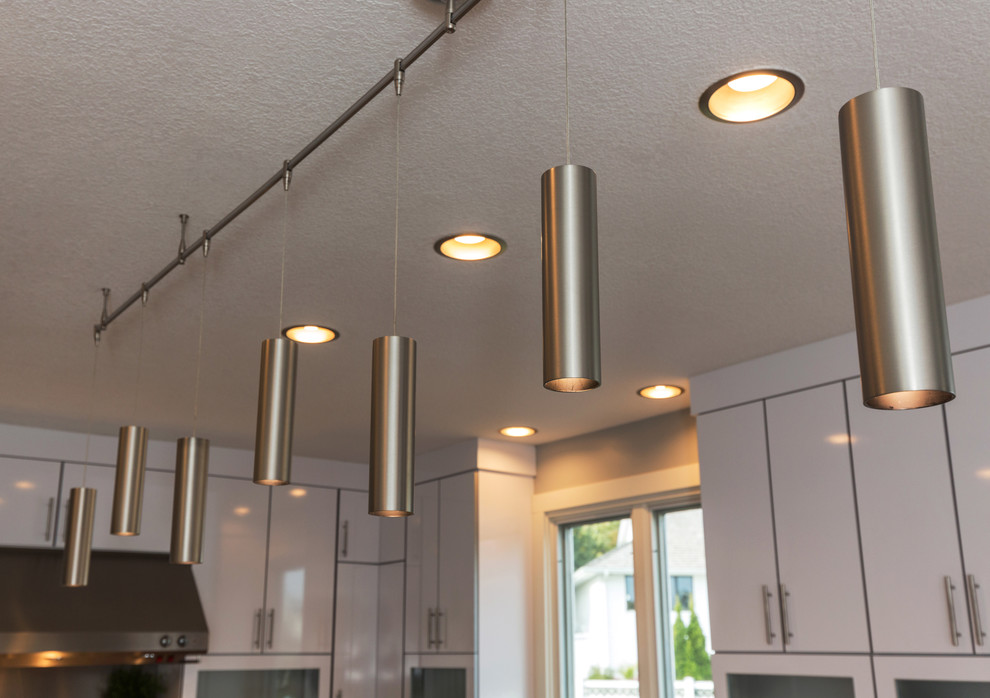 Inspiration for a large contemporary u-shaped light wood floor open concept kitchen remodel with an undermount sink, flat-panel cabinets, white cabinets, granite countertops, multicolored backsplash, mosaic tile backsplash, stainless steel appliances and an island