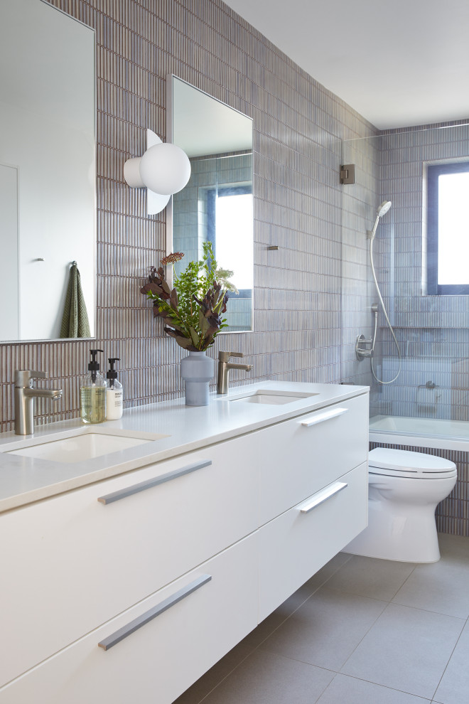 Example of a mid-sized minimalist kids' blue tile and mosaic tile porcelain tile, gray floor and double-sink bathroom design in San Francisco with flat-panel cabinets, white cabinets, a one-piece toilet, an undermount sink, quartz countertops, a hinged shower door, a floating vanity and white countertops
