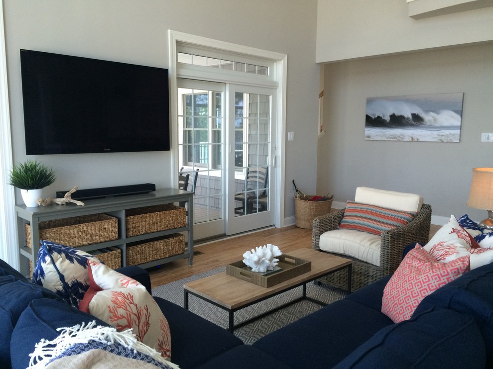 Photo of a mid-sized beach style enclosed family room in Philadelphia with grey walls, light hardwood floors, no fireplace and a wall-mounted tv.