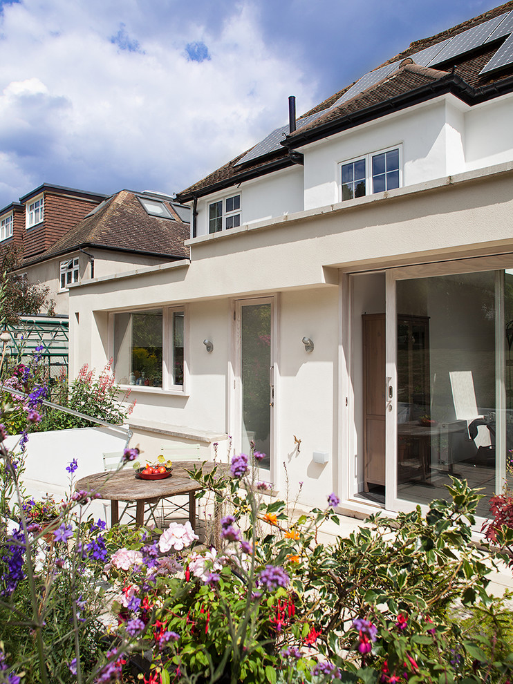 Design ideas for a large contemporary two-storey stucco white exterior in London.