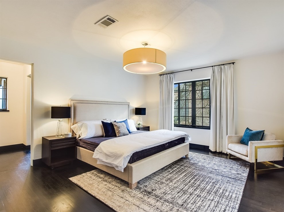 This is an example of a mediterranean master bedroom in Austin with beige walls, dark hardwood floors and brown floor.