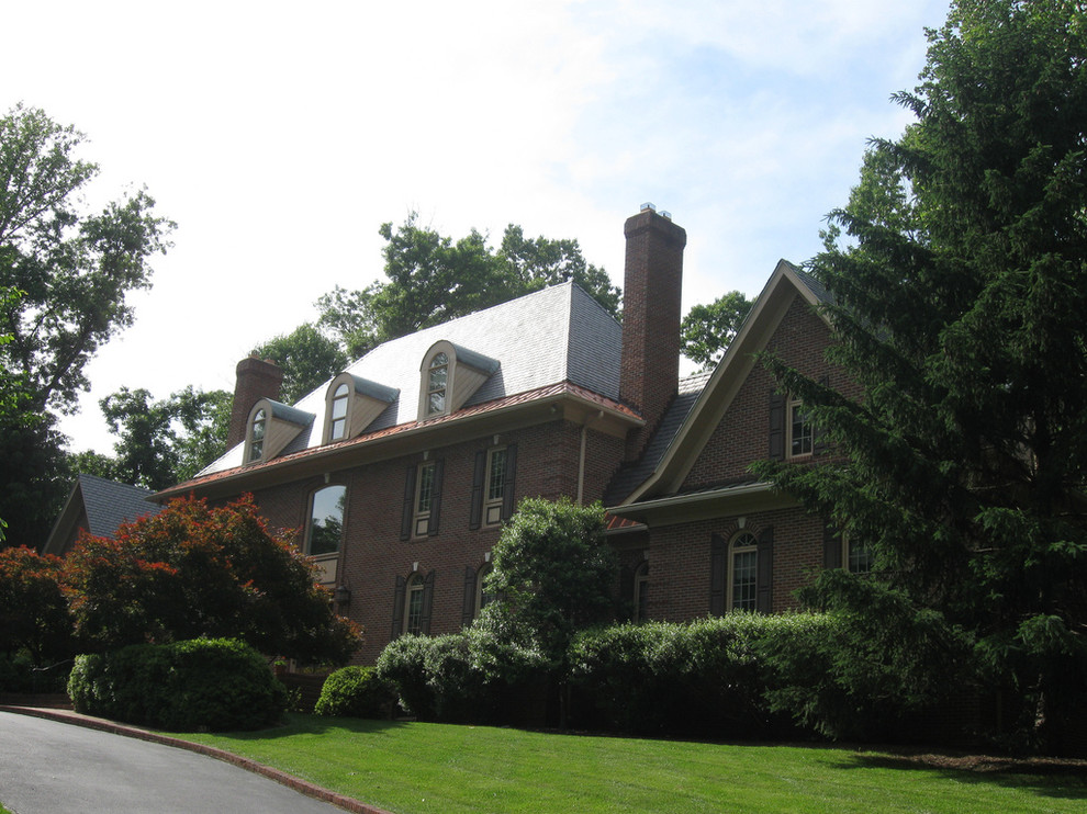 This is an example of a large traditional two-storey brick red house exterior in DC Metro with a hip roof and a shingle roof.