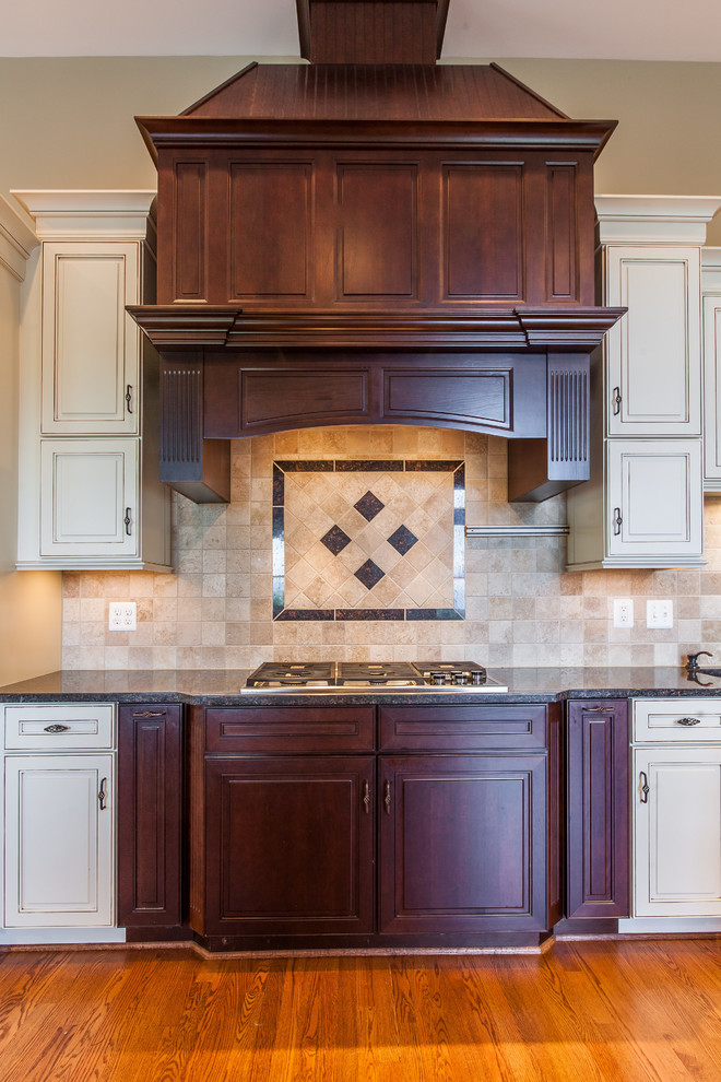 Eat-in kitchen - huge transitional medium tone wood floor eat-in kitchen idea in DC Metro with raised-panel cabinets, granite countertops, stainless steel appliances and an island