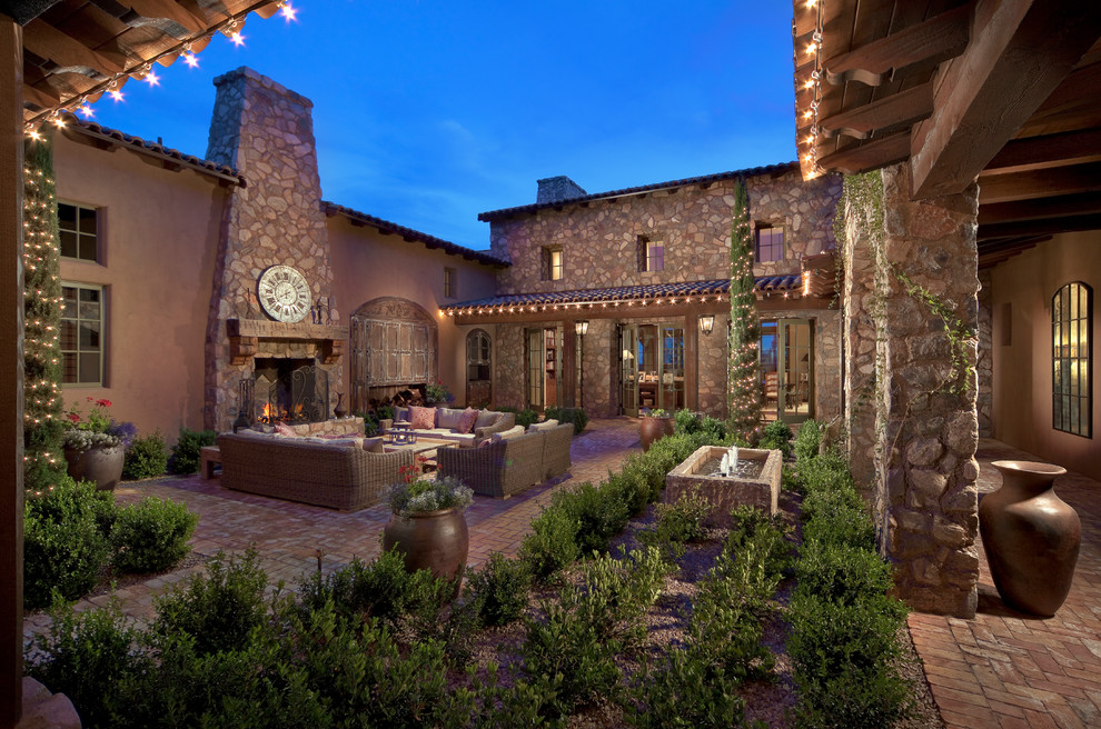 Design ideas for a mediterranean courtyard patio in Phoenix with a fire feature and no cover.