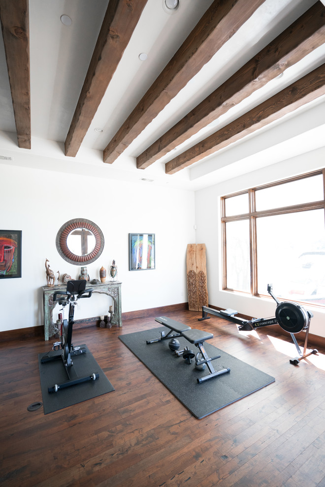 This is an example of a home gym in Austin with dark hardwood floors.