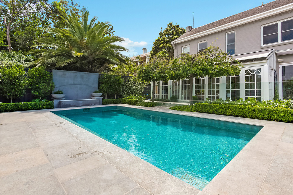 Inspiration for a mid-sized traditional backyard rectangular lap pool in Melbourne with concrete pavers.