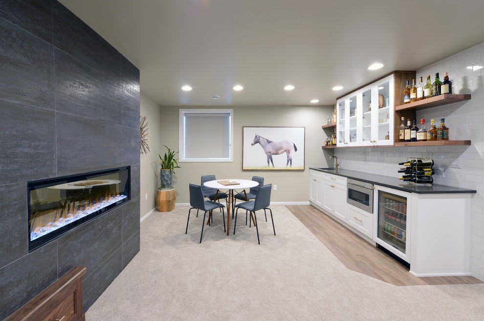 Large modern look-out basement in Other with grey walls, carpet, a two-sided fireplace, a wood fireplace surround and beige floor.