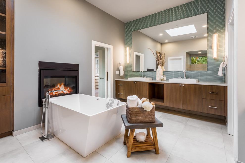 Inspiration for a contemporary master bathroom in Seattle with flat-panel cabinets, medium wood cabinets, a freestanding tub, green tile, grey walls, a vessel sink, grey floor and white benchtops.