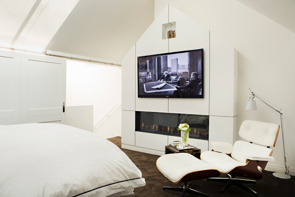 This is an example of a mid-sized contemporary bedroom in Los Angeles with white walls, carpet and a ribbon fireplace.