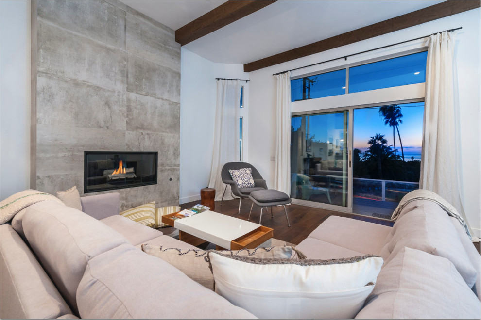 Design ideas for a mid-sized transitional open concept living room in San Diego with white walls, medium hardwood floors, a standard fireplace and a concrete fireplace surround.