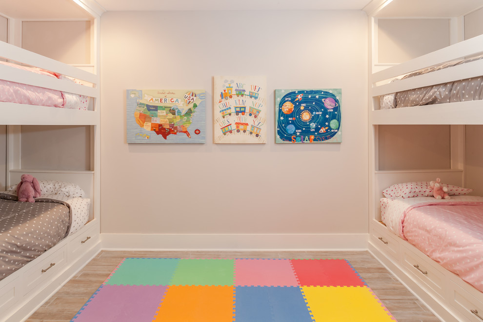 Photo of a mid-sized beach style kids' bedroom for kids 4-10 years old and girls in New York with pink walls and light hardwood floors.