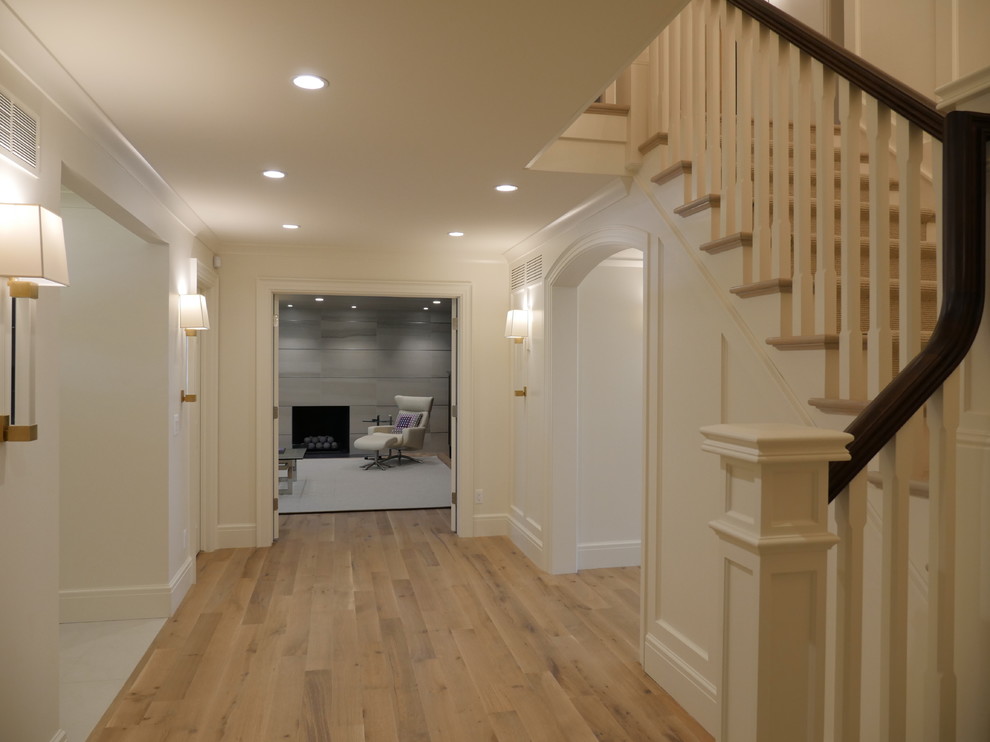 Inspiration for a large transitional foyer in Detroit with white walls and medium hardwood floors.