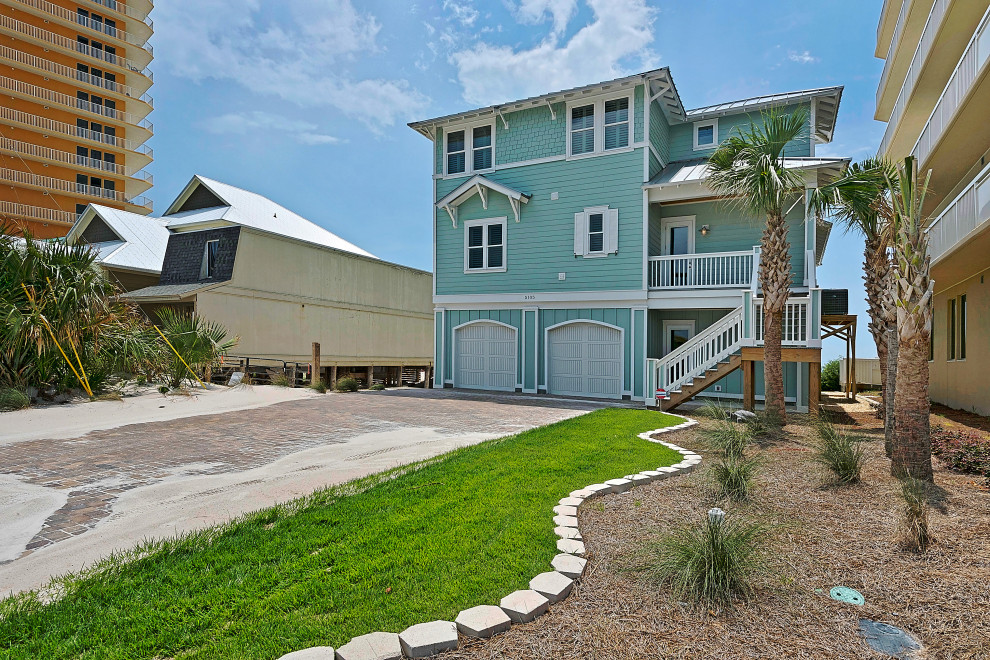 Huge beach style blue concrete fiberboard and clapboard house exterior photo with a hip roof, a metal roof and a gray roof