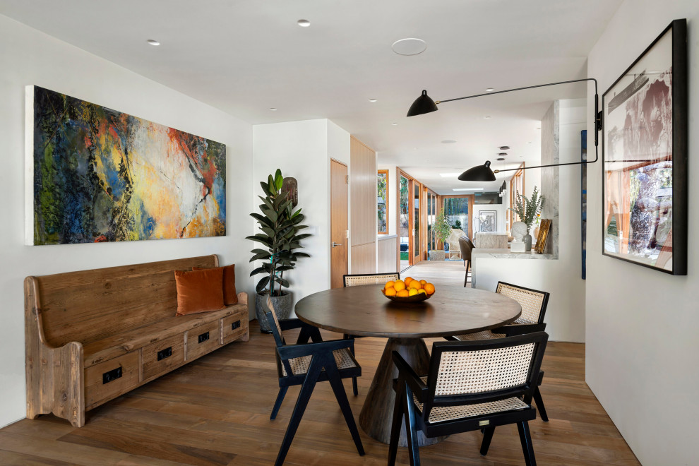 Idée de décoration pour une petite salle à manger design avec un mur blanc, aucune cheminée, un sol marron et un sol en bois brun.