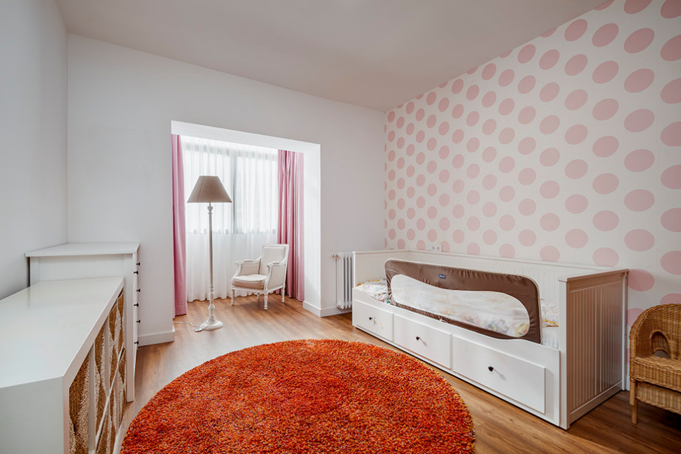Inspiration for a contemporary kids' playroom for kids 4-10 years old and girls in Madrid with pink walls, medium hardwood floors and brown floor.
