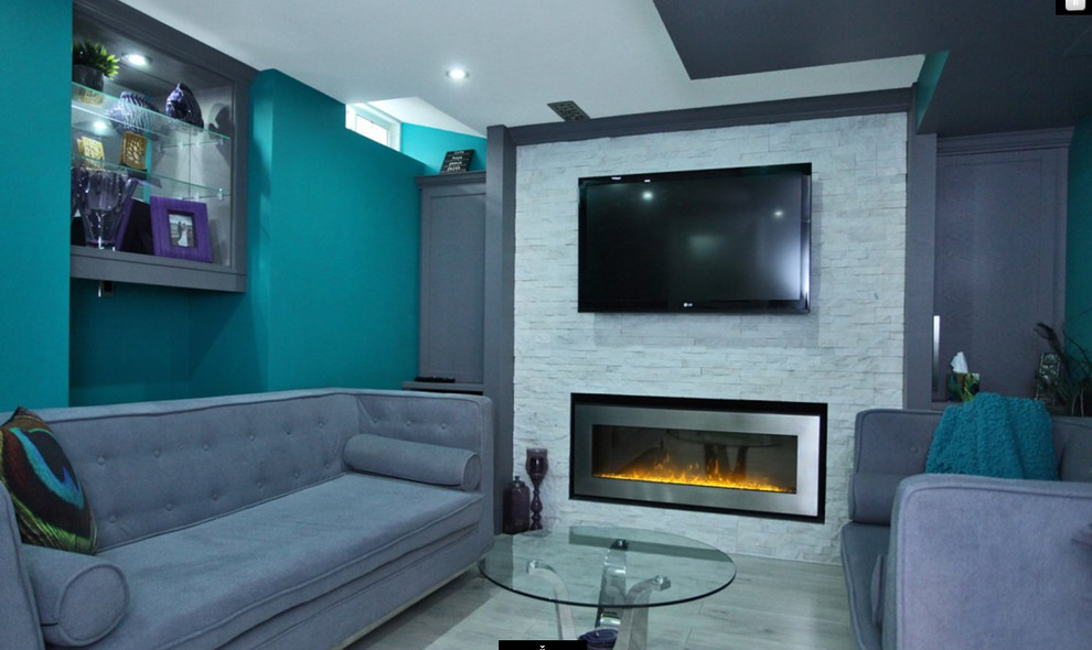Inspiration for a transitional look-out laminate floor and gray floor basement remodel in Toronto with multicolored walls, a standard fireplace and a stone fireplace