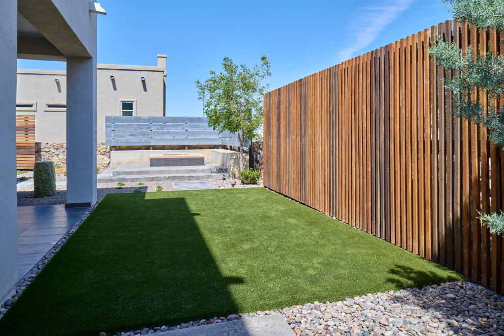 Cette image montre un petit jardin latéral design avec un chemin, une terrasse en bois et une clôture en bois.