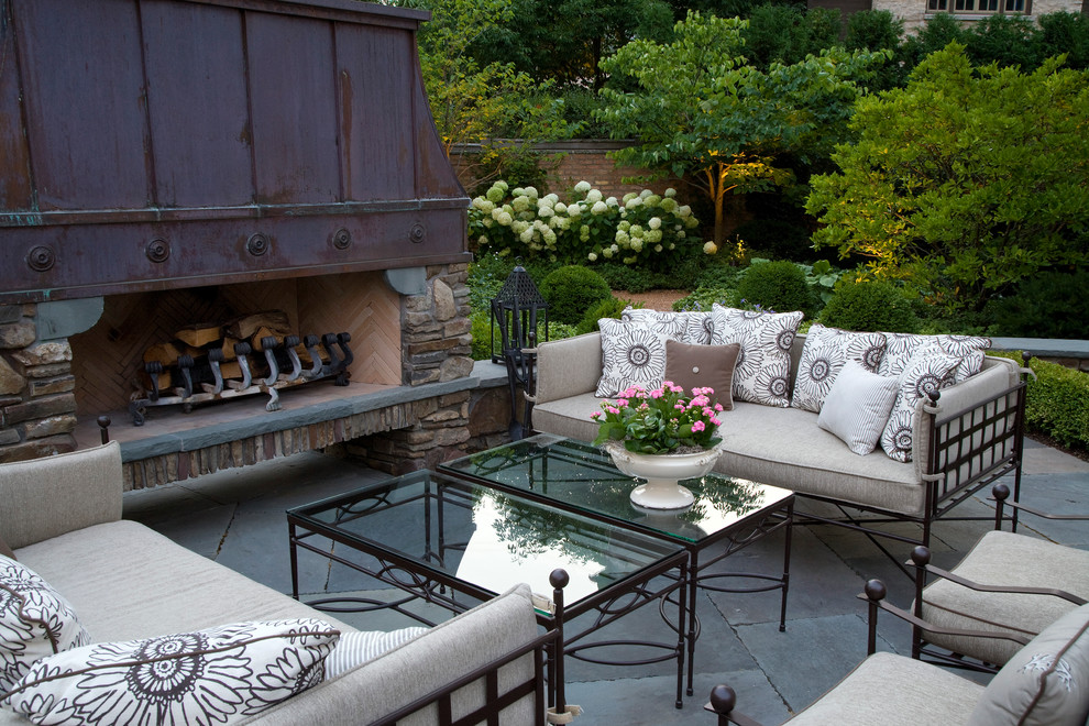 Large traditional backyard patio in Chicago with natural stone pavers and a fire feature.