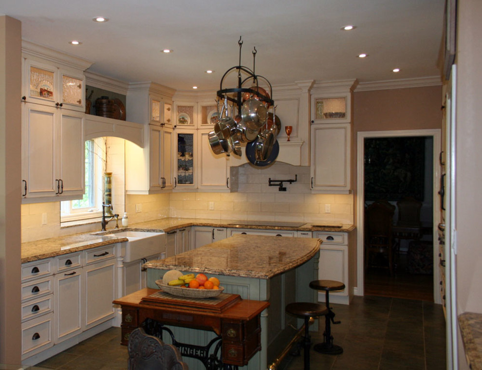This is an example of a large traditional u-shaped eat-in kitchen in Toronto with a farmhouse sink, beaded inset cabinets, distressed cabinets, quartz benchtops, beige splashback, subway tile splashback, panelled appliances, ceramic floors and with island.