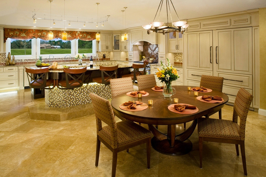 Example of a large transitional travertine floor eat-in kitchen design in Jacksonville with light wood cabinets, granite countertops, multicolored backsplash, paneled appliances, raised-panel cabinets, mosaic tile backsplash and two islands