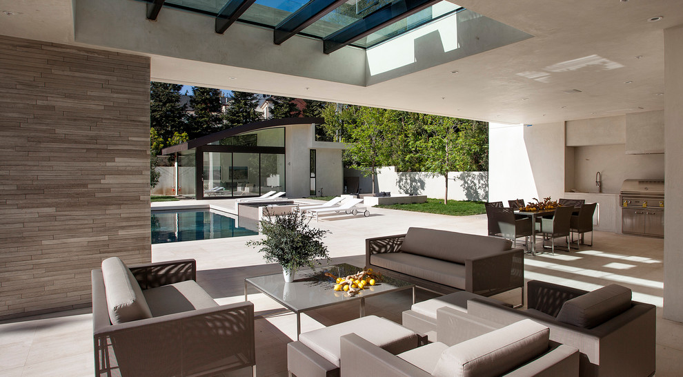 Contemporary backyard patio in Los Angeles with a roof extension.