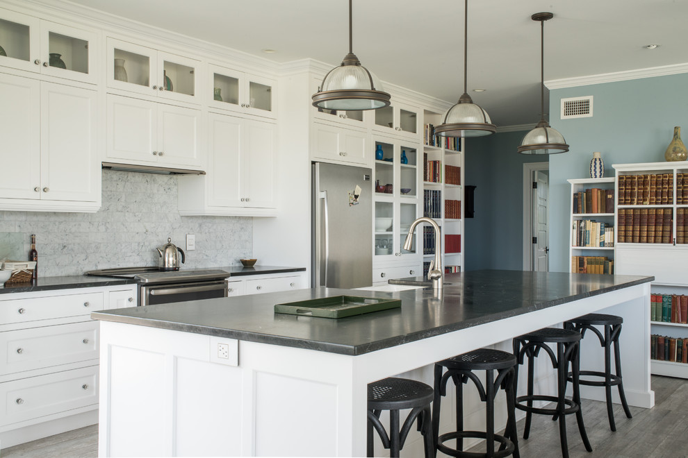 Inspiration for an expansive arts and crafts kitchen in Boston with an integrated sink, recessed-panel cabinets, white cabinets, solid surface benchtops, white splashback, stone tile splashback, stainless steel appliances, ceramic floors and with island.